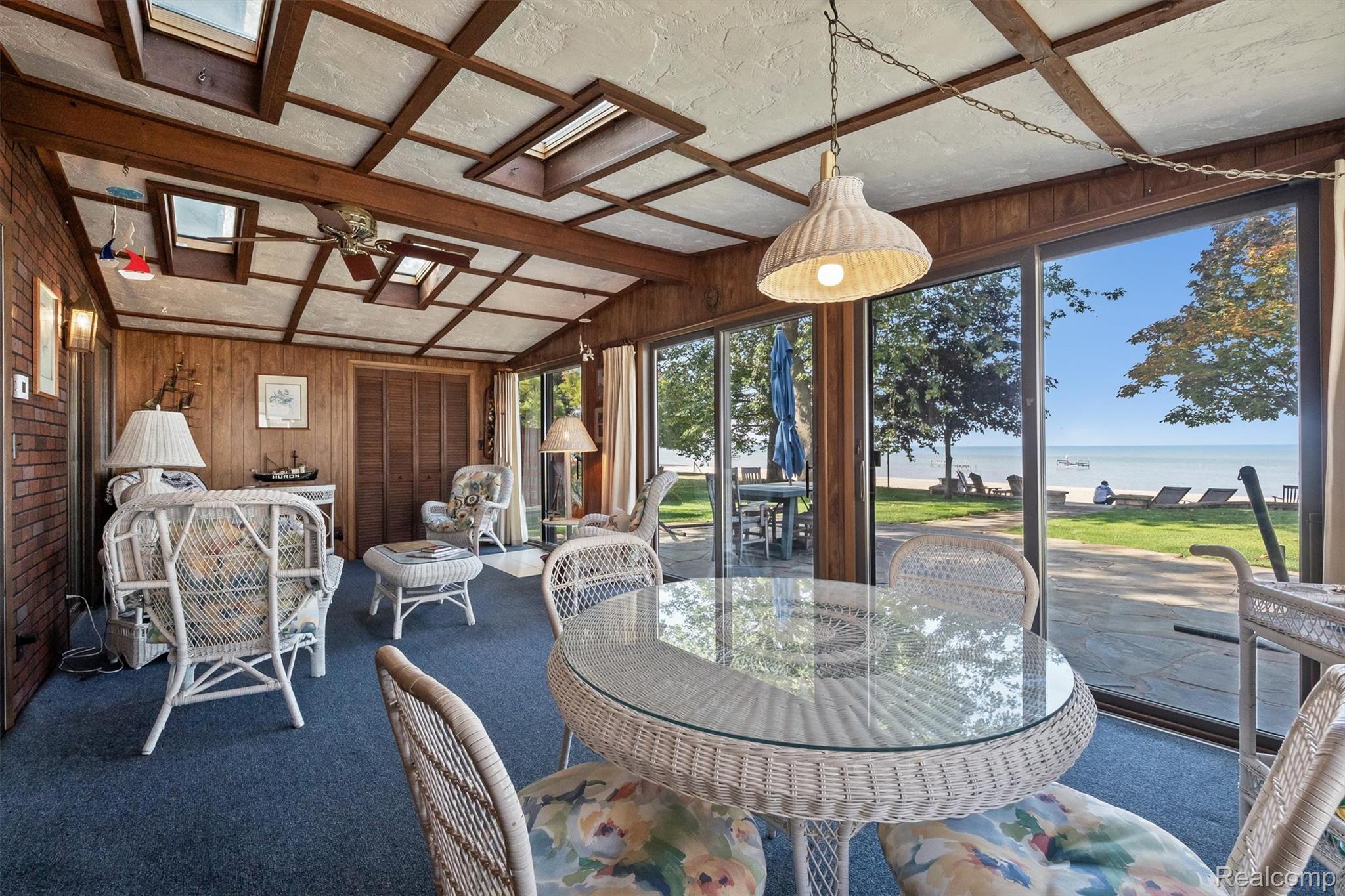 5892 Port Austin Road Caseville, MI 48725 - Photo 13 of 42 Sunroom / solarium featuring wood walls, a water view, carpet, a skylight, and beamed ceiling