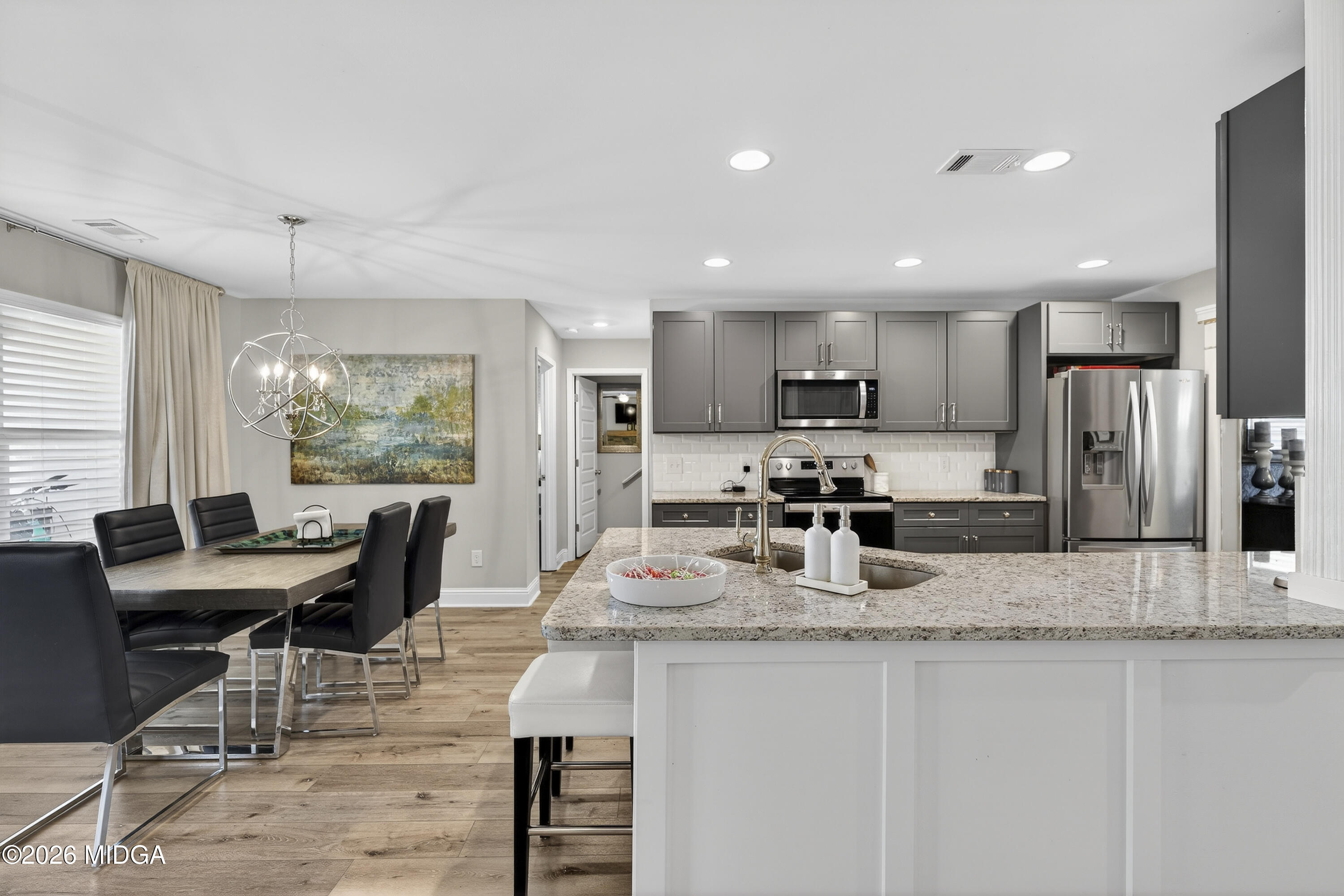 737 Springhill Drive Gray, GA 31032 - Photo 18 of 60 a kitchen with stainless steel appliances granite countertop a stove a refrigerator a sink a dining table and chairs