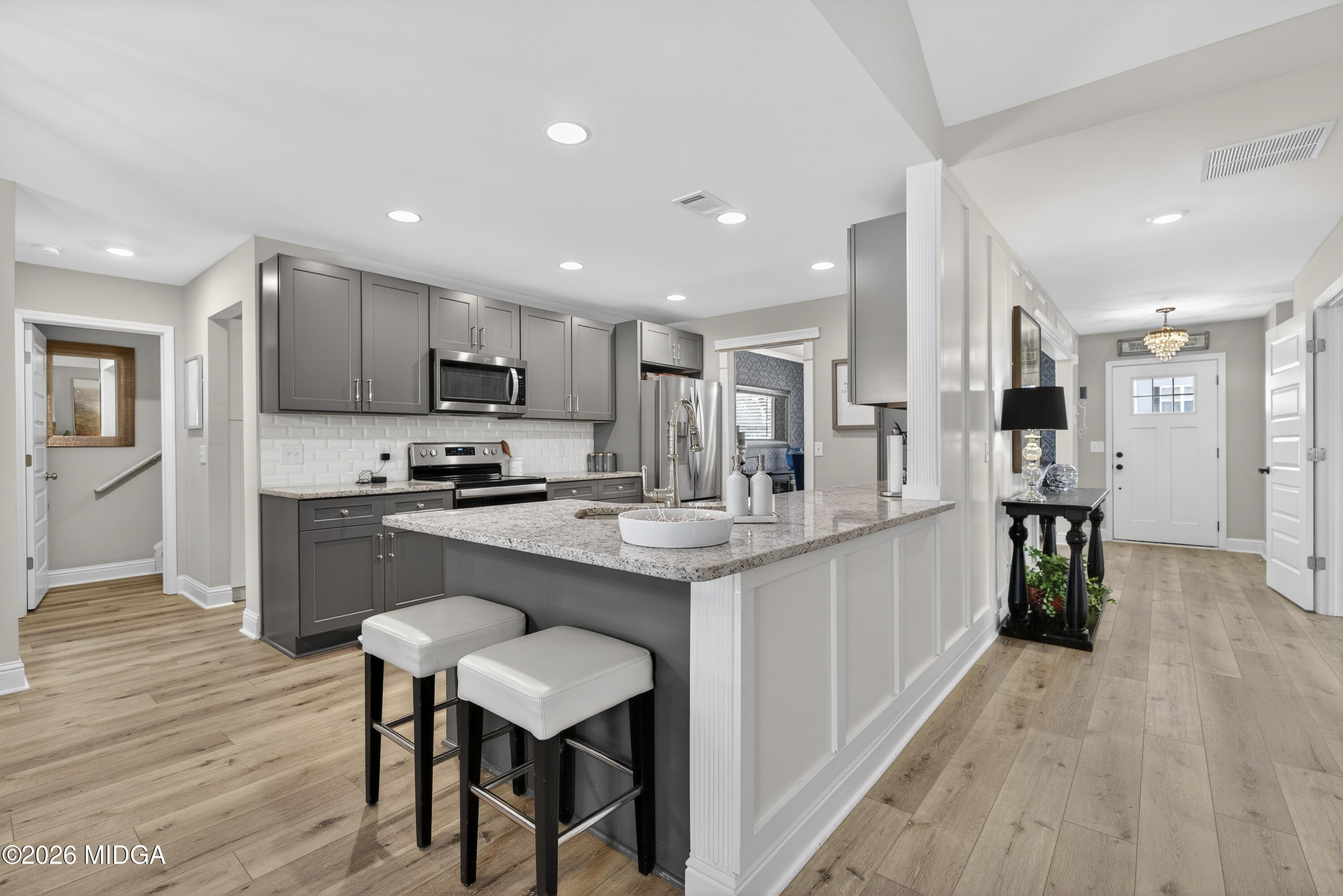 737 Springhill Drive Gray, GA 31032 - Photo 19 of 60 a kitchen with kitchen island granite countertop wooden floors and refrigerator