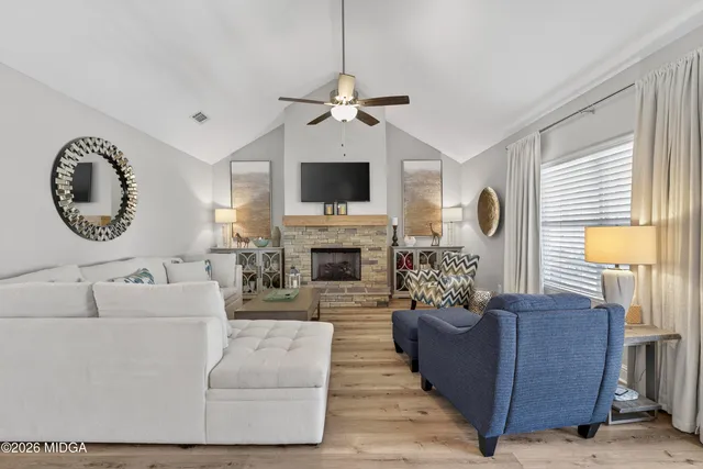 a living room with furniture a clock on wall and a clock