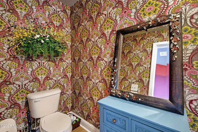 a spacious bedroom with a bed a couch and a chandelier