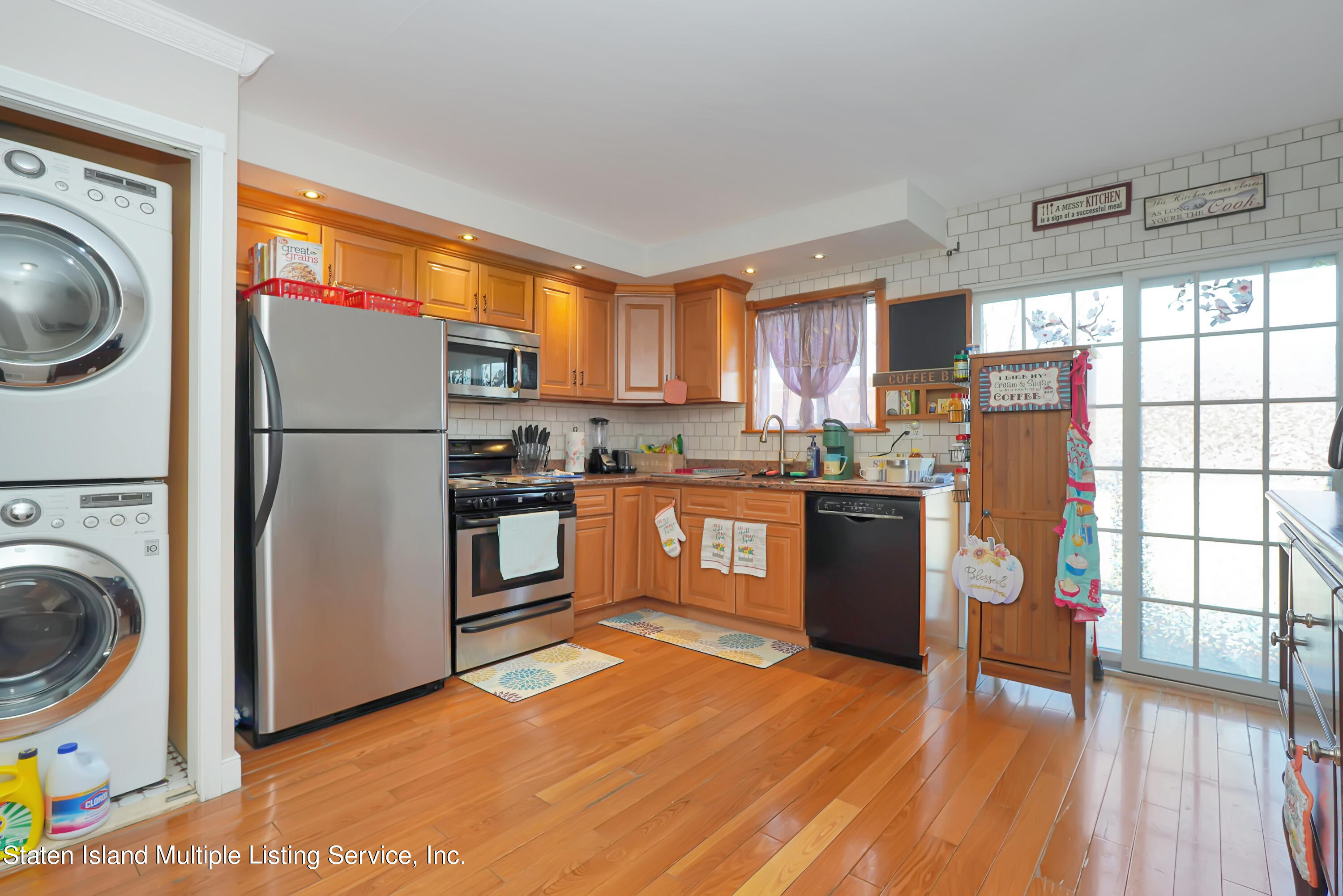 258 Edgewater Street Staten Island, NY 10305 - Photo 10 of 33 a kitchen with a refrigerator a stove top oven a sink and dishwasher with wooden floor