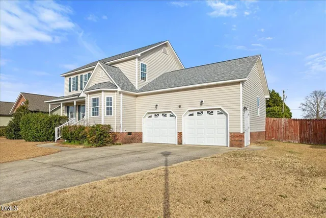 a view of a livingroom with a fireplace a chandelier fan and windows