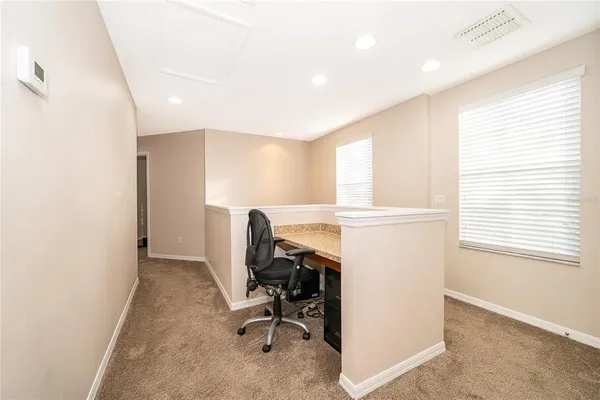 a view of a workspace with furniture and a window