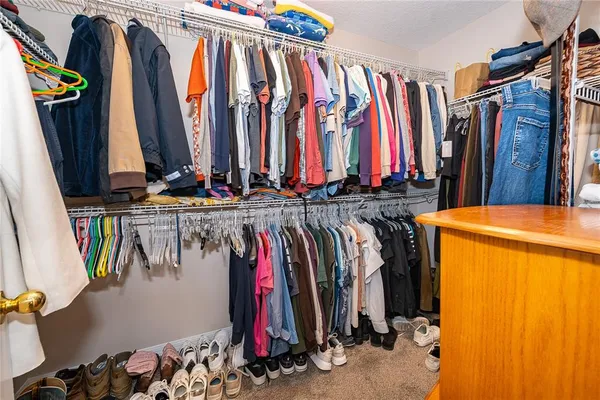 a view of walk in closet with clothes