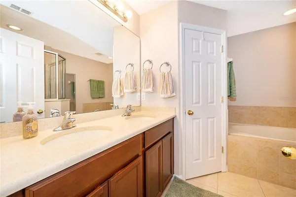 a bathroom with a double vanity sink a mirror and a bathtub