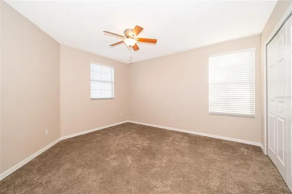 an empty room with windows and fan