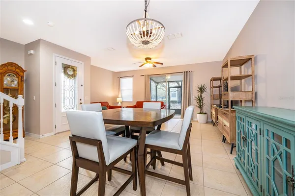 a dining room with furniture a chandelier and wooden floor