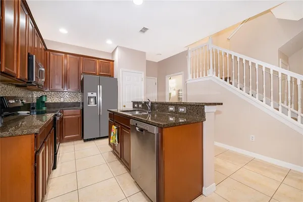 a kitchen with stainless steel appliances granite countertop a stove a sink and a refrigerator
