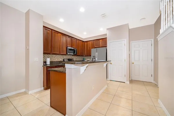 a kitchen with stainless steel appliances granite countertop a refrigerator sink and cabinets