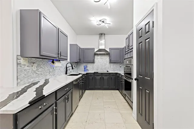 a kitchen with granite countertop a sink stove and cabinets