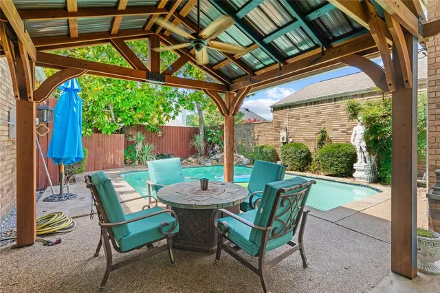 a view of a patio with a table chairs and a backyard