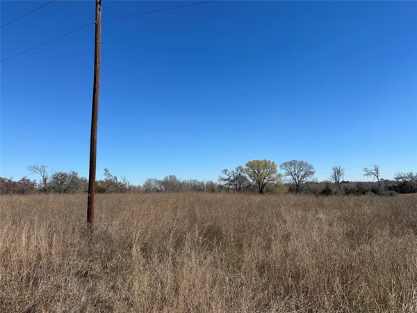 a view of a field with a building in the background