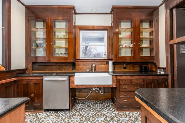 a large kitchen with stainless steel appliances a large counter top a stove a sink and a window