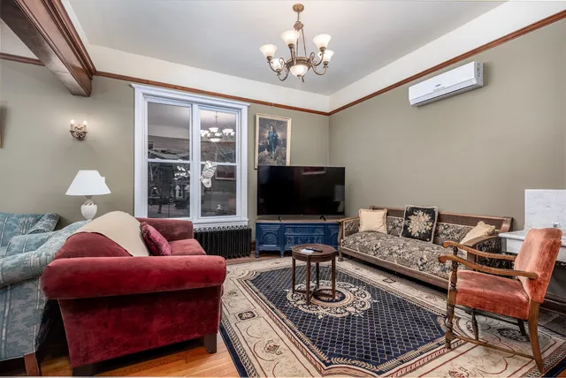 a living room with furniture a chandelier and a bookshelf