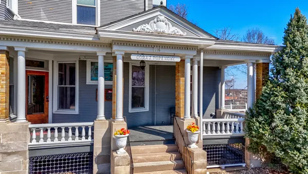 a living room with furniture a chandelier and a bookshelf