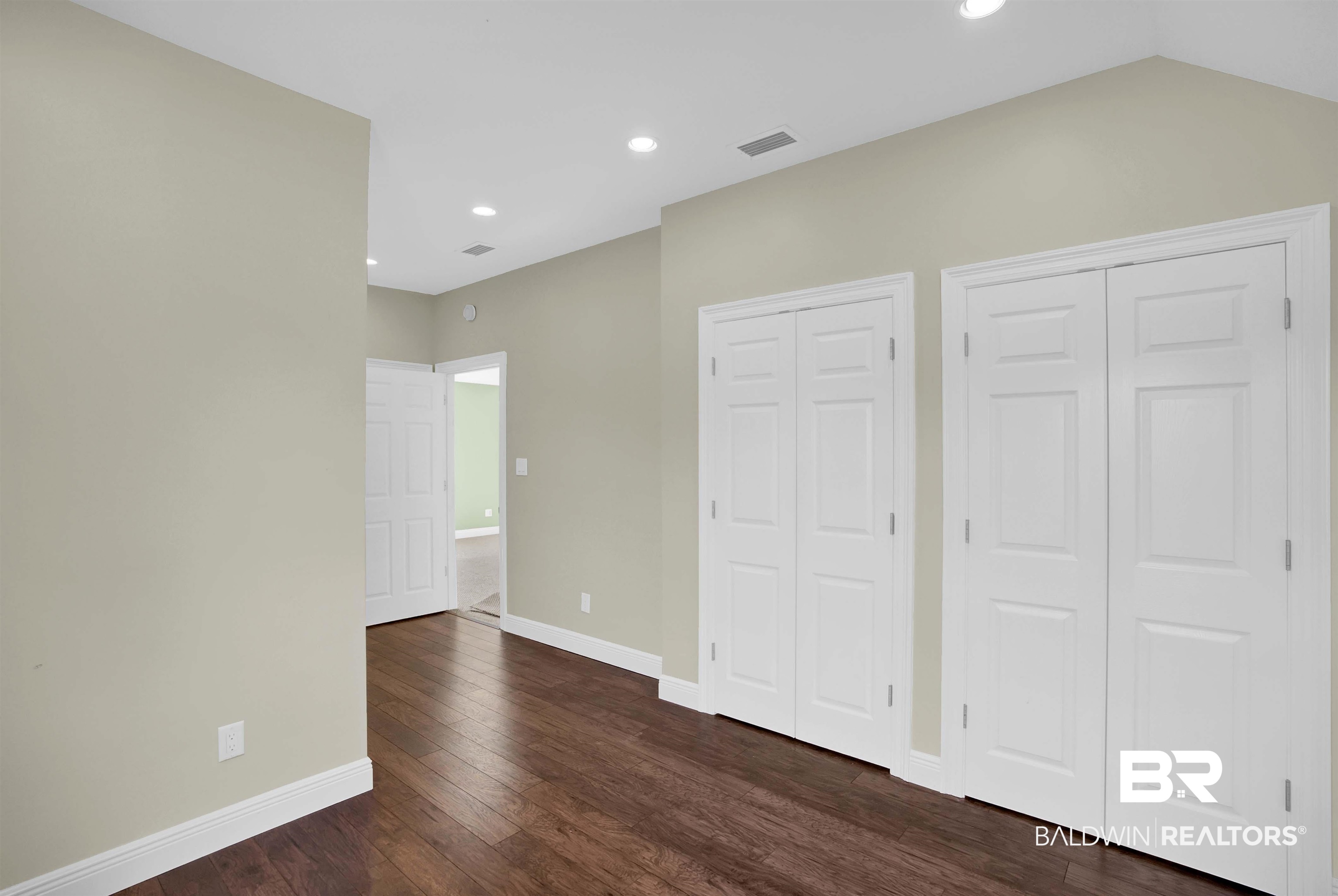 27688 Rigsby Road Daphne, AL 36526 - Photo 41 of 56 Unfurnished bedroom with lofted ceiling, multiple closets, and dark hardwood / wood-style floors