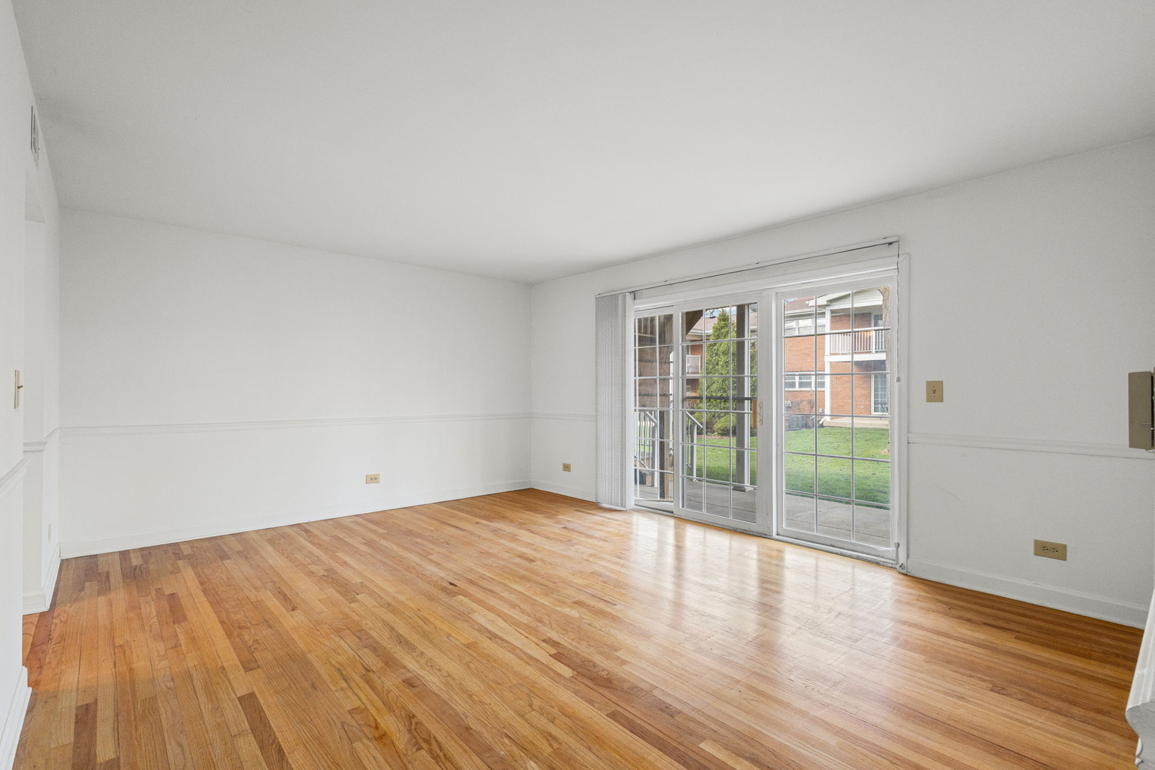 169 East Palatine Road, Unit E Palatine, IL 60067 - Photo 11 of 24 a view of an empty room with wooden floor and a window