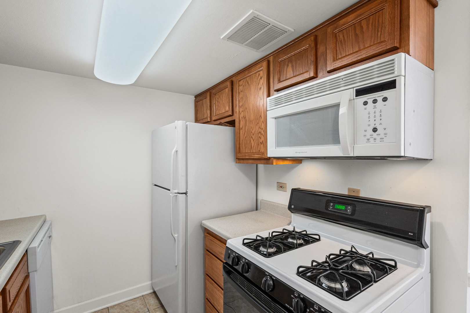 169 East Palatine Road, Unit E Palatine, IL 60067 - Photo 5 of 24 a stove top oven sitting inside of a kitchen