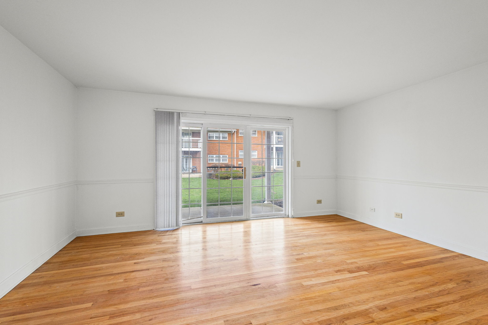 169 East Palatine Road, Unit E Palatine, IL 60067 - Photo 9 of 24 a view of an empty room with wooden floor and a window