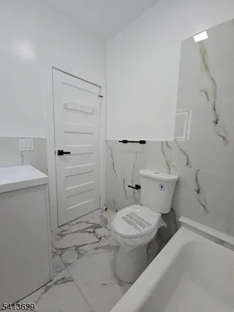 a white toilet sitting next to a bathroom sink and vanity