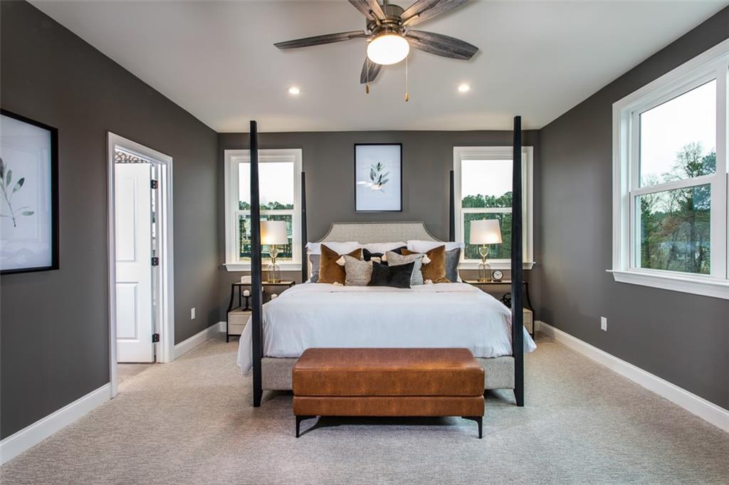 4840 Montane Street Cumming, GA 30028 - Photo 20 of 34 a bed room with a bed and a chandelier