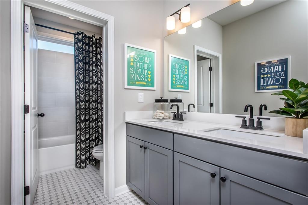 4840 Montane Street Cumming, GA 30028 - Photo 25 of 34 a bathroom with a sink a large mirror and a shower