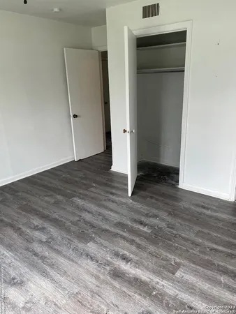 a view of empty room with wooden floor