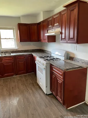 a kitchen with stainless steel appliances granite countertop wooden cabinets stove top oven and sink
