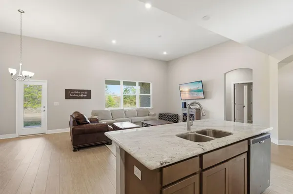 a kitchen with a sink a counter space and living room
