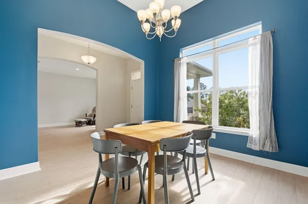 a view of a dining room with furniture a chandelier and wooden floor