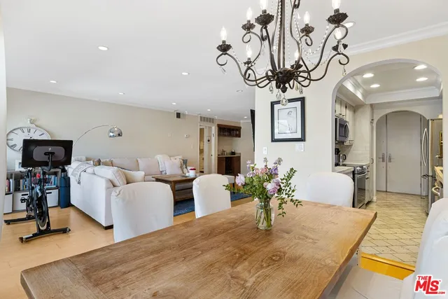 a living room with furniture a chandelier and a wooden floor