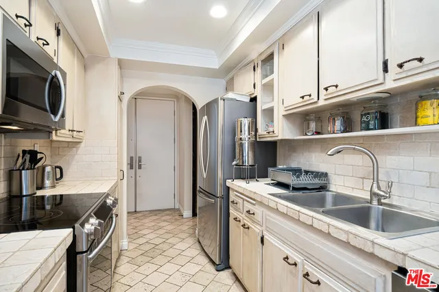 a kitchen with stainless steel appliances granite countertop a sink a stove and a refrigerator