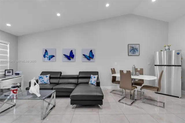 a living room with furniture and a refrigerator