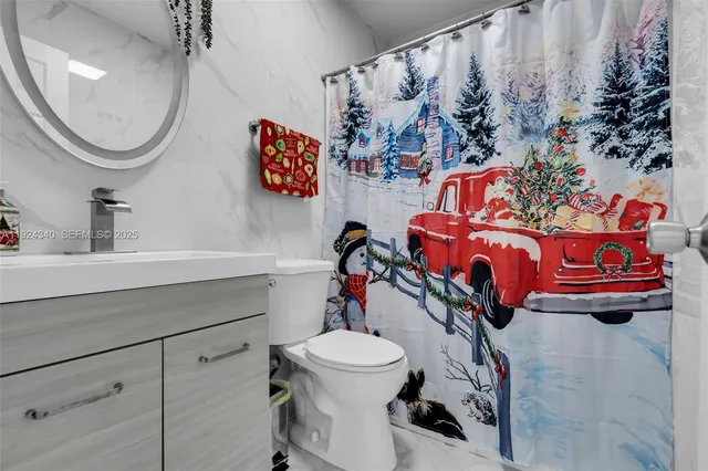 a bathroom with a sink mirror and toilet