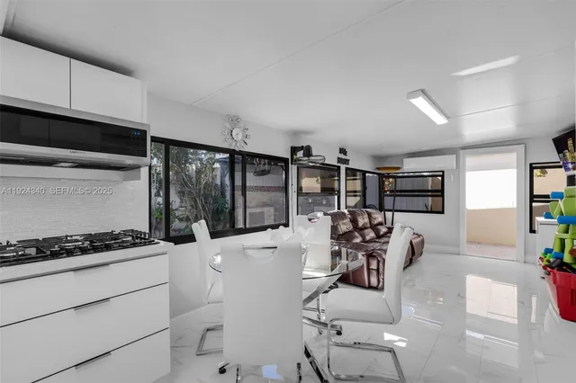 a kitchen with stainless steel appliances kitchen island granite countertop a stove and white cabinets