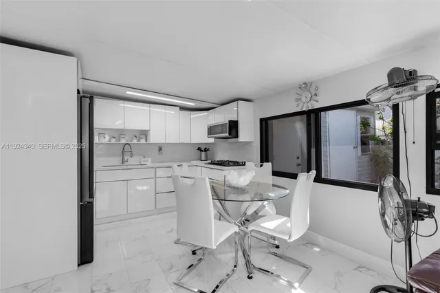 a kitchen with a refrigerator and white cabinets