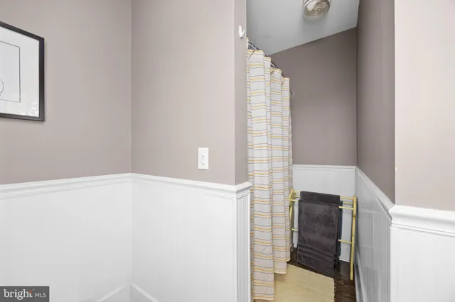 a backyard of a house with plants and large tree