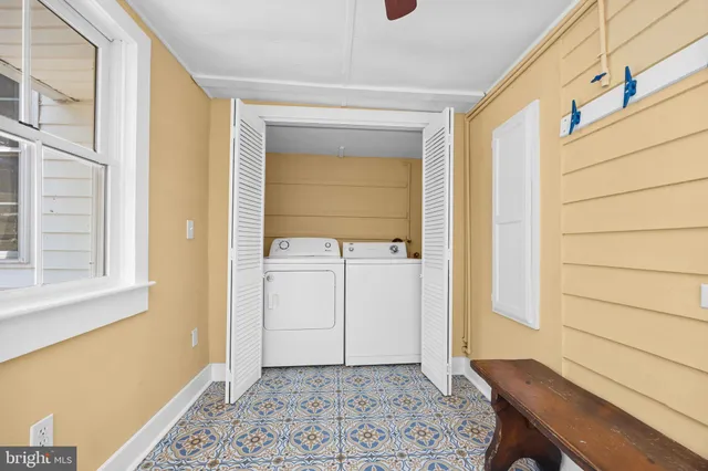 a view of a white house with a yard and large trees