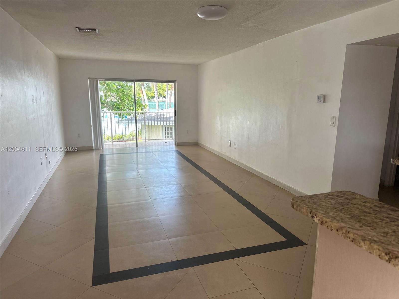 7424 Southwest 82nd Street, Unit D216 Miami, FL 33143 - Photo 2 of 9 an empty room with wooden floor and windows