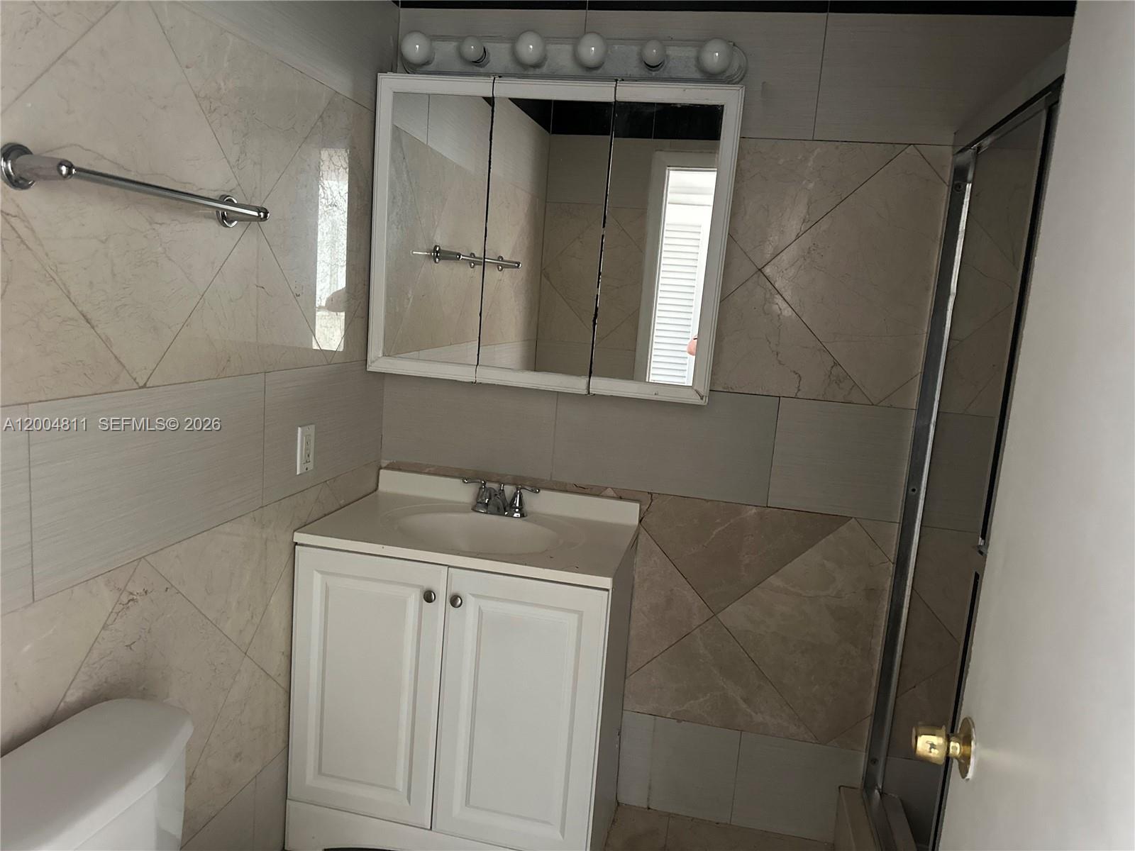 7424 Southwest 82nd Street, Unit D216 Miami, FL 33143 - Photo 6 of 9 a bathroom with a granite countertop sink toilet and shower
