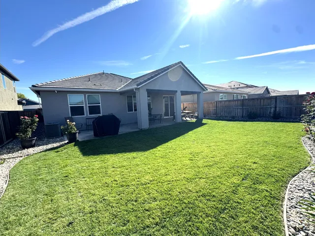 a view of a house with a yard and furniture