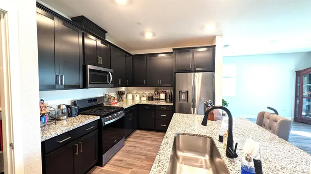 a kitchen with granite countertop stainless steel appliances and refrigerator