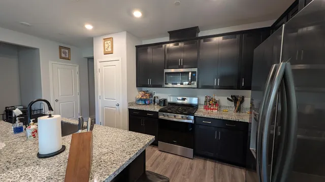 a kitchen with kitchen island granite countertop stainless steel appliances and sink