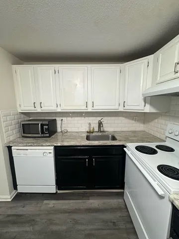 a kitchen with stainless steel appliances granite countertop a sink and a stove