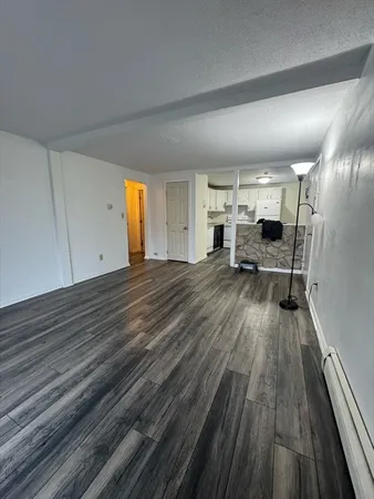 a view of a living room hardwood floor and a kitchen counter space