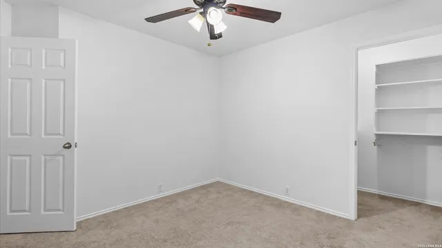 an empty room with a chandelier fan
