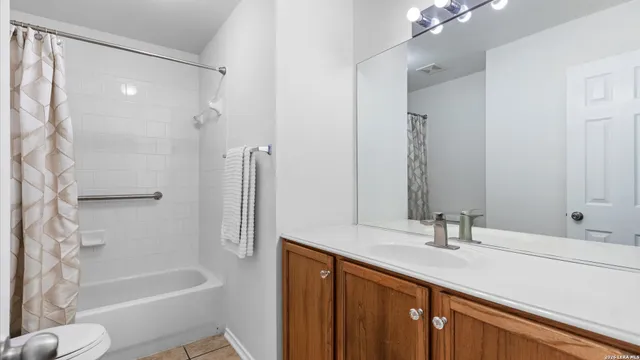 a bathroom with a tub sink and mirror