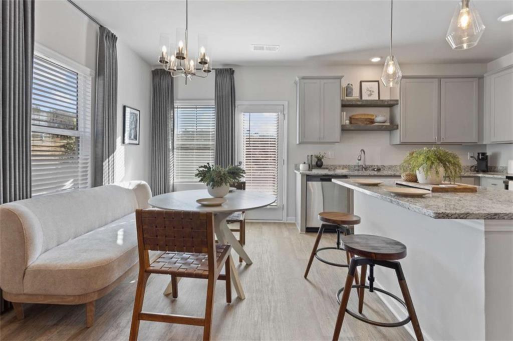 126 Meadowview Drive, Unit 13 Temple, GA 30179 - Photo 6 of 26 a kitchen with a dining table chairs and white cabinets