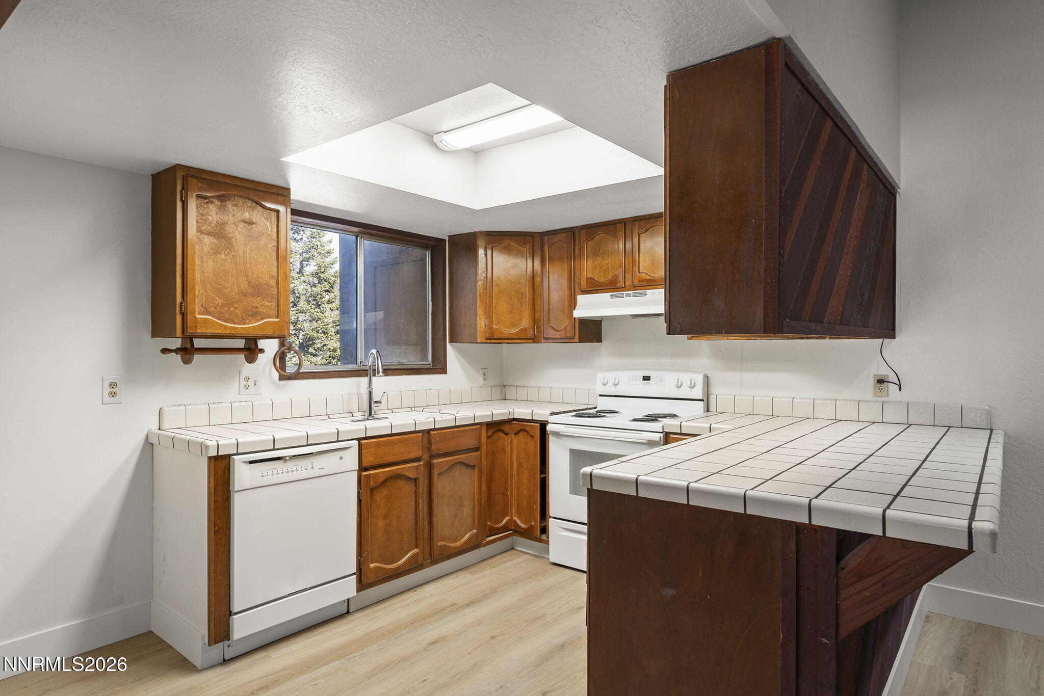 179 Tramway Drive, Unit B Stateline, NV 89449 - Photo 11 of 29 a kitchen with a sink dishwasher a stove a microwave oven and a cabinets with wooden floor